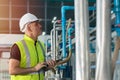 Engineer in factory working to check boiler water pipe in factory hand holding tablet Royalty Free Stock Photo