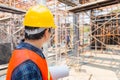 Engineer / foreman checking and planning project at construction site, Man holding blueprint with blurred background Royalty Free Stock Photo