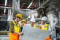 Engineer and Foreman are discussing the plant layout on the blueprint in the factory boiler room