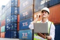 Engineer or foreman use walkie-talkie and laptop. In order to move container and shipping. Safety helmet help prevent accident Royalty Free Stock Photo