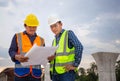 Engineer and foreman worker checking project at building site, Engineer and builders in hardhats discussing blueprint on Royalty Free Stock Photo