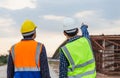 Engineer and foreman worker checking project at building site, Engineer and builders in hardhats discussing on construction site, Royalty Free Stock Photo