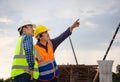 Engineer and foreman worker checking project at building site, Engineer and builders in hardhats in infrastructure construction Royalty Free Stock Photo