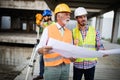 Engineer, foreman and worker discussing in building construction site