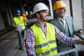 Engineer, foreman and worker discussing in building construction site