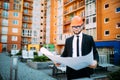 Engineer in front of modern building with plan looking at blueprint Royalty Free Stock Photo