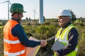 Engineer and geologist consult close to wind turbines in the countryside Royalty Free Stock Photo