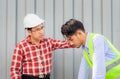 Engineer give advice foreman worker at construction site, Serious factory worker in hard hat at cargo container