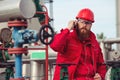 Engineer in hard-hat. Face behind pipeline machinery, fuel and oil refinery.