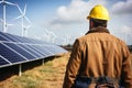 Engineer with hard hat inspects wind and solar power station