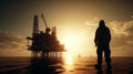 An engineer in a hard hat stands in front of an oil-producing industrial platform. Factory worker with equipment for oil