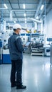 Engineer in hard hat using digital tablet on factory floor with modern equipment Royalty Free Stock Photo