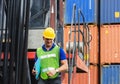 Engineer in hardhat on stacker lifting container control loading containers box, Dock worker man with clipboard checklist on