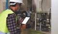 Engineer in hardhat is using digital tablet in a factory Royalty Free Stock Photo