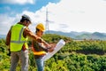 Engineer head point to the planer paper and discuss with his team for the construction near the forest with copy space in image Royalty Free Stock Photo