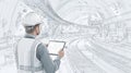 Engineer with helmet and vest using digital tablet in subway tunnel construction site with curved railway track Royalty Free Stock Photo