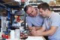 Engineer Helping Male Apprentice In Factory To Measure Component Royalty Free Stock Photo