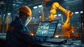 An engineer in a high-tech manufacturing setting is programming or operating advanced automated machinery using a Royalty Free Stock Photo
