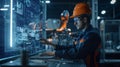 An engineer in a high-tech manufacturing setting is programming or operating advanced automated machinery using a Royalty Free Stock Photo