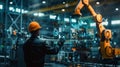 An engineer in a high-tech manufacturing setting is programming or operating advanced automated machinery using a Royalty Free Stock Photo