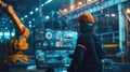 An engineer in a high-tech manufacturing setting is programming or operating advanced automated machinery using a Royalty Free Stock Photo