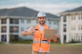 Engineer hold paper board for text. Builder showing signboard placard banner, poster. Serious engineer at new home