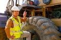 The engineer hold walky talky stand near the tractor and smile to show happy emotion of his work Royalty Free Stock Photo