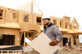 Engineer holding architecture drawing plan on paper at construction site. Royalty Free Stock Photo