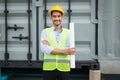 engineer holding blueprint and standing at construction site area. he smile after construction complete. Royalty Free Stock Photo