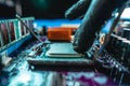 Engineer holding hands CPU to insert into the socket of the motherboard. Technology hardware and repair in neon light Royalty Free Stock Photo