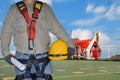 Engineer holding yellow helmet for the safety and wearing full safety harness Royalty Free Stock Photo