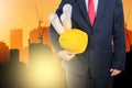 engineer holding yellow helmet for workers security on background of new highrise apartment buildings Royalty Free Stock Photo