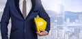 Engineer holding yellow Safety hardhat with building background Royalty Free Stock Photo