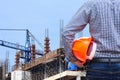 Engineer holding yellow safety helmet in building construction site with crane Royalty Free Stock Photo