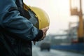 Engineer holds hard hat helmet, prioritizing safety on construction site