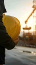 Engineer holds hard hat helmet, prioritizing safety on construction site