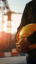 Engineer holds hard hat helmet, prioritizing safety on construction site