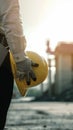 Engineer holds hard hat helmet, prioritizing safety on construction site