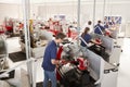 Engineer inspecting apprentices at their workstations