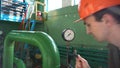 Engineer inspecting old water pump at factory