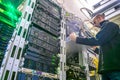 The engineer installs the new equipment in the server rack of the data center. The technical specialist works in the server room.