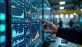 Engineer interacts with SCADA system interface. Person uses computer screen displaying data charts. Data acquisition, analysis.