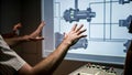An engineer interacts with a virtual control panel projected in midair hand gestures manipulating 3D schematics of