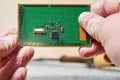 An engineer keeps and examines the PCB with a microchip in tech laboratory