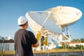 Engineer looking earth based astronomical radio telescope Royalty Free Stock Photo