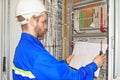 Engineer is looking at electrical drawing diagram in electrical automation cabinet and control of industrial equipment. Royalty Free Stock Photo
