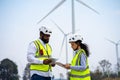 Engineer male and female on wind turbine farm. Two engineers discussed the plan for the maintenance of wind turbines