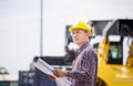 Engineer man with blueprint checking and inspect container in industry cargo, Foreman dock worker in hardhat control loading