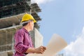 Engineer man with clipping path checking and planning project at construction site, Man holding blueprint and looking into the sky Royalty Free Stock Photo