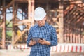 Engineer man with digital tablet checking project at the building site, Foreman worker at infrastructure construction site Royalty Free Stock Photo